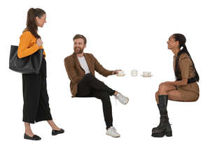 woman talking to two friends sitting in a cafe