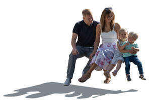 cut out backlit man and woman and two small children sitting