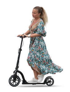 woman in a flowy summer dress riding a scooter