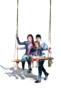 family sitting on a swing in a park