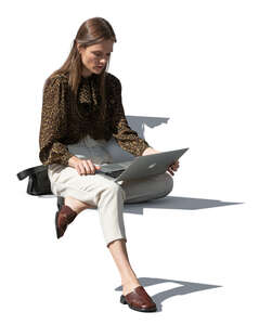 young woman sitting outside and working with laptop