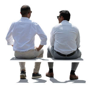 two backlit middle eastern men sitting