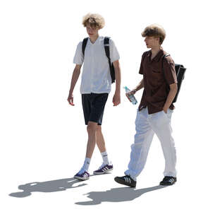two backlit teenage boys walking