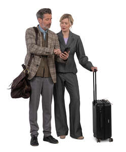 two people with travel bags standing and looking at a phone