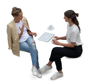 top view of two women sitting and drinking coffee
