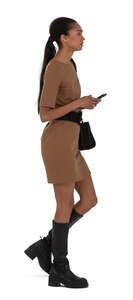 woman in a brown dress and knee high boots walking