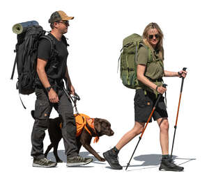 two cut out hikers with backpacks and a dog walking