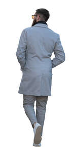 bearded man in a grey overcoat walking