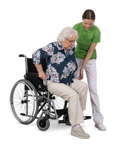physical therapist helping a woman in the wheelchair to stand up