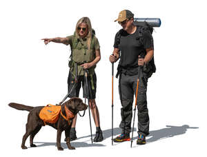 hikers with a dog standing and pointing at smth