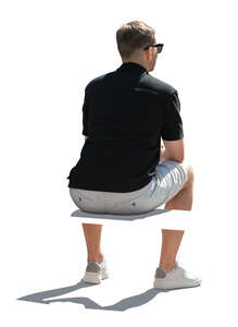 backlit man sitting seen from back angle