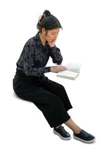 cut out asian woman sitting and reading seen from above