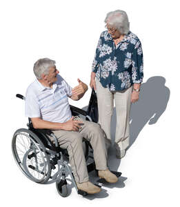 elderly man in a wheelchair talking to a woman someone seen from above