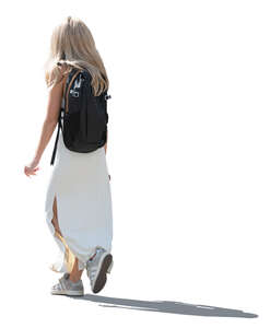 backlit woman in a white casual summer dress walking