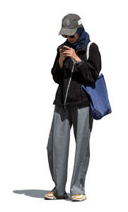 cut out woman with a baseball hat looking at her phone