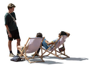 man talking to two friends sitting in outdoor chairs