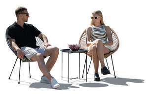 man and woman sitting in armchairs outdoors
