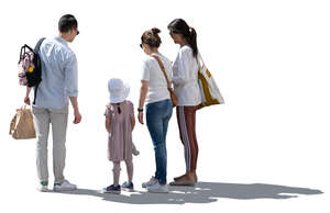 backlit group of adults and a child standing