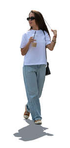 backlit asian woman with a coffee drink walking