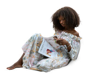 black woman sitting on a sofa and reading a magazine