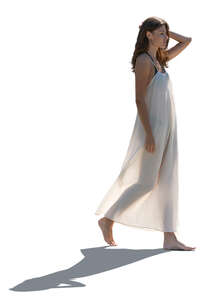 woman in a light beach dress walking barefoot