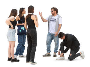 group of people meeting in the street and one man tying shoelaces