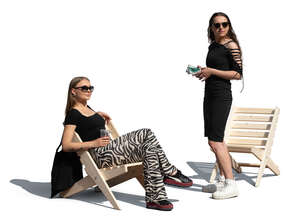 one woman standing and and one woman sitting and looking around