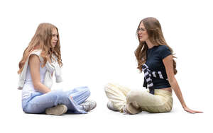 two teenage girls sitting on the ground and talking