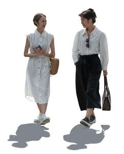 two backlit asian women walking