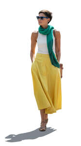 backlit woman in a colourful outfit walking