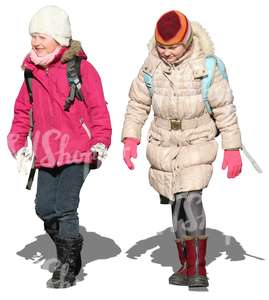 two girls with schoolbags walking in winter