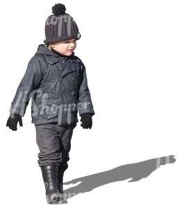 small boy in a black jacket walking