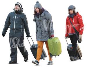 three people carrying suitcases in winter