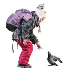 schoolgirl standing and looking at a pigeon