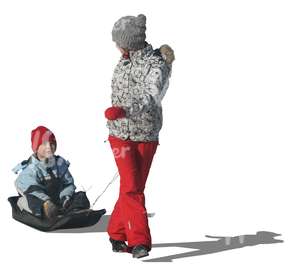 woman pulling a sledge with her son