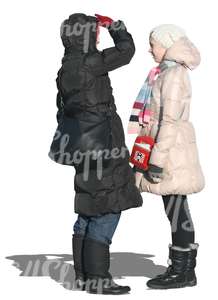 two cut out women in winter coats talking