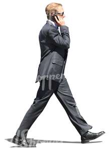 man in a suit walking and talking on the phone