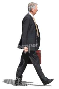 older businessman walking with a briefcase in his hand