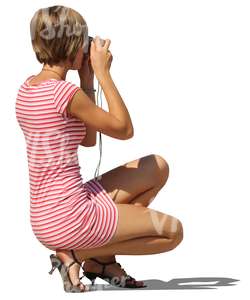 cut out woman squatting and taking a picture