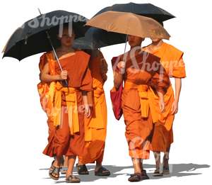 four buddhist monks walking with umbrellas