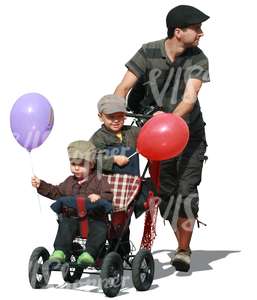 man pushing a baby stroller with two boys in it