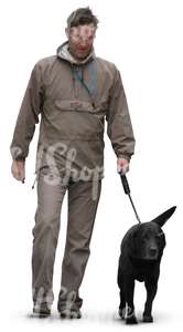 man walking a black dog