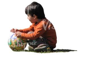 boy with a ball squatting on the grass