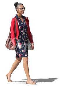 black woman in a blue dress walking and smiling