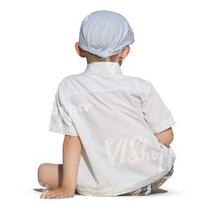 young boy in white sitting on the ground