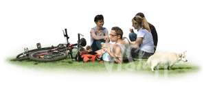 group of four people with bicycles and a dog having a picnic