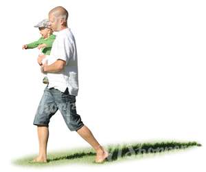 man walking on the grass hoding his son in his arms 