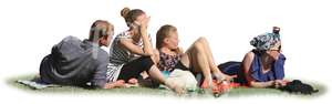 group of four people sitting on the grass