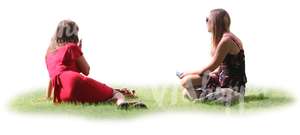 two women sitting together on the grass