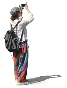 woman with a backpack standing and taking a picture